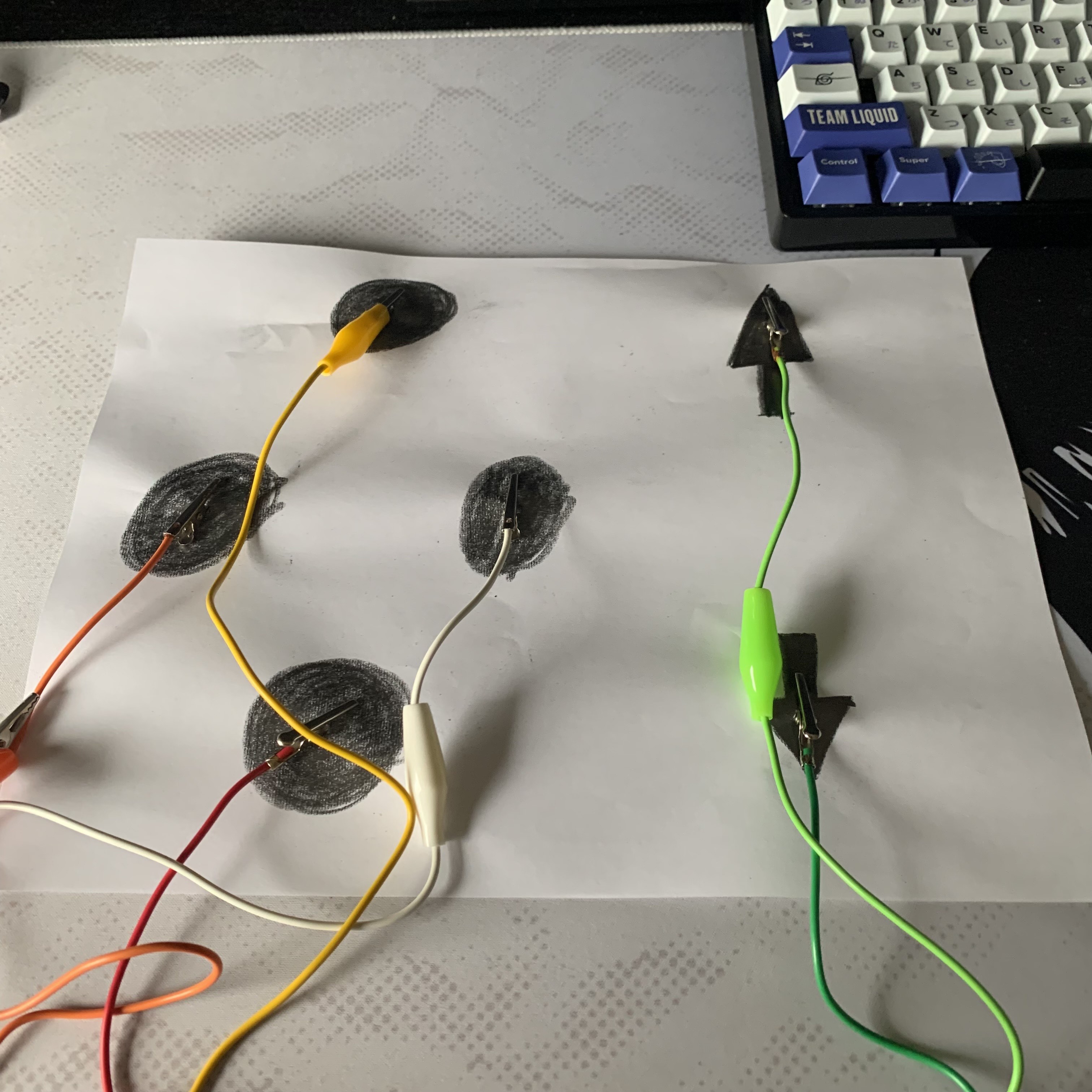 Showing the attachments of the alligator clips to the paper and graphite pencil sketched area.