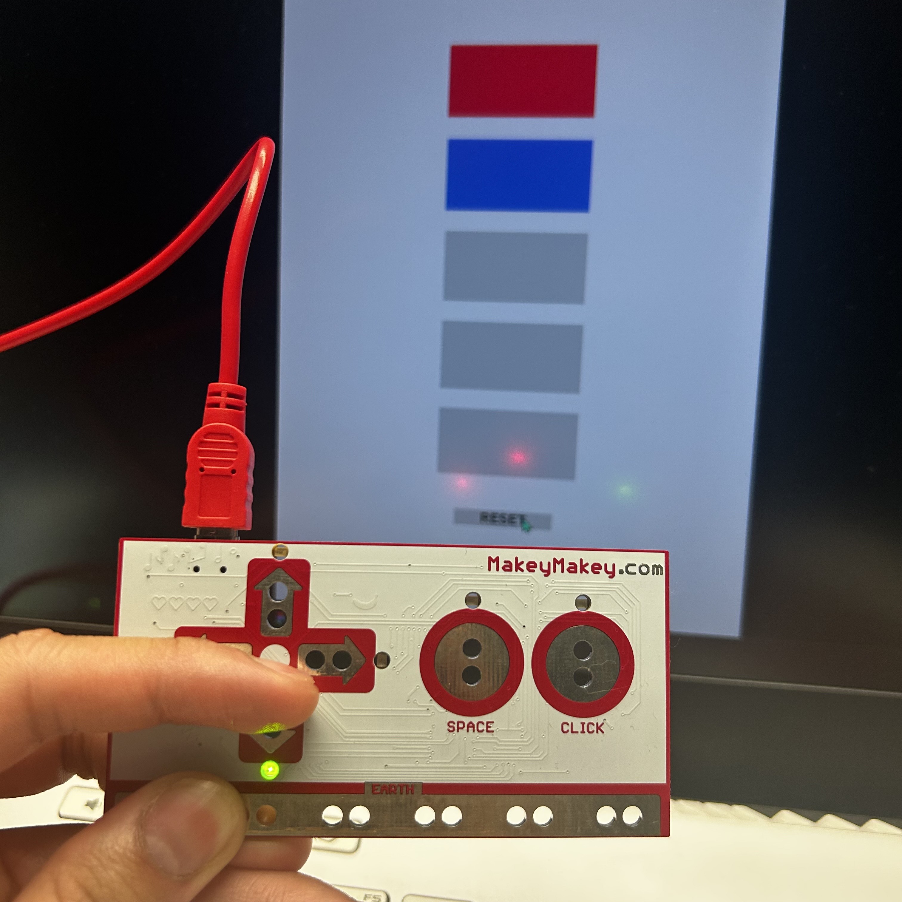 This is a photo successfully capturing the physical connection of me touching the different Makey Makey buttons and the monitor reads it correctly.